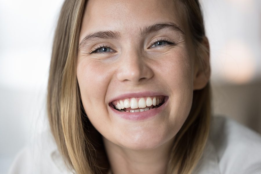 Happy beautiful young girl looking at camera with toothy smile