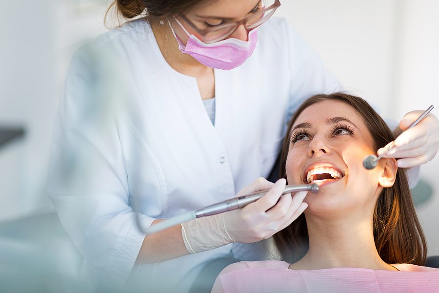 Female patient smiling up at the female dentist during an exam. 