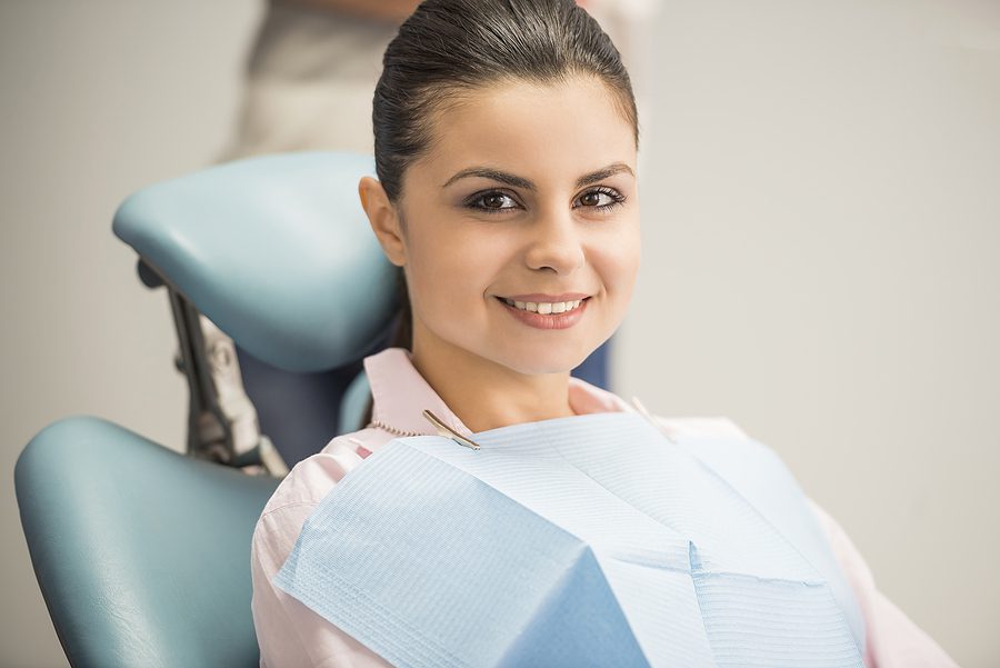 Young female patient smiling and happy about her recent dental procedure. 